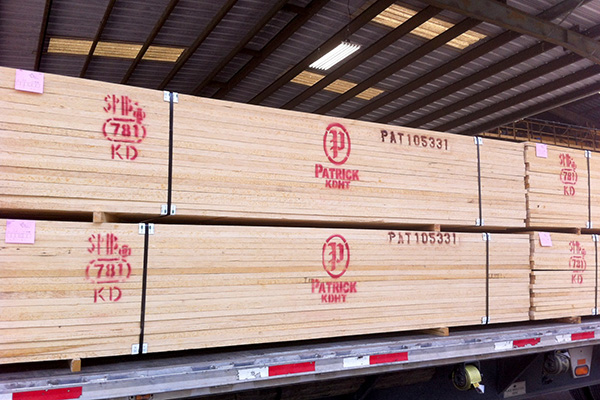 Lumber loaded onto a truck stamped with Patrick Lumber's red logo